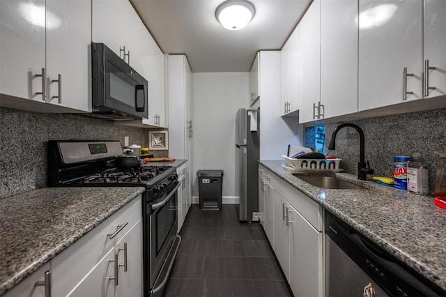 kitchen with white cabinets, decorative backsplash, stainless steel appliances, and dark stone countertops