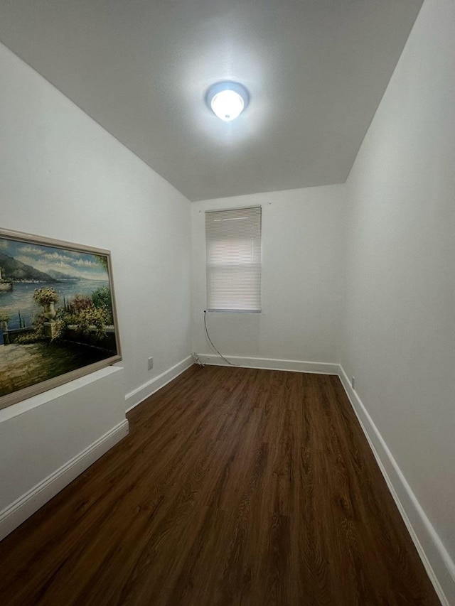 empty room featuring dark hardwood / wood-style flooring and lofted ceiling