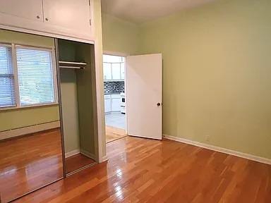 unfurnished bedroom featuring light wood-type flooring and a closet