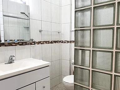 bathroom with toilet, vanity, and tile walls