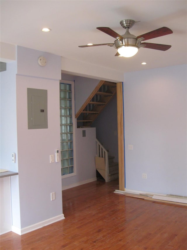 empty room featuring ceiling fan, wood-type flooring, and electric panel