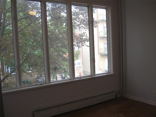 unfurnished room with a baseboard heating unit