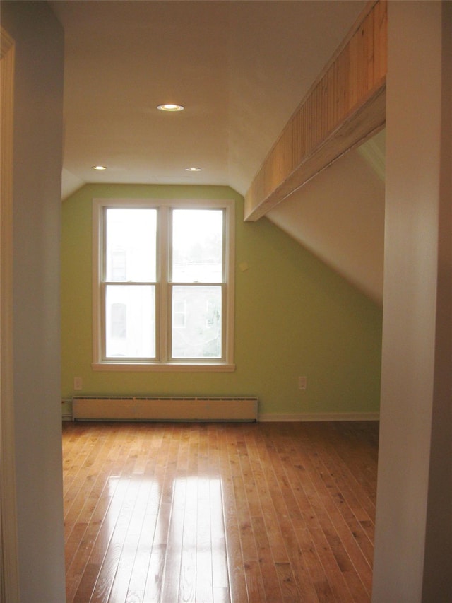 bonus room featuring baseboard heating, lofted ceiling, and light hardwood / wood-style floors