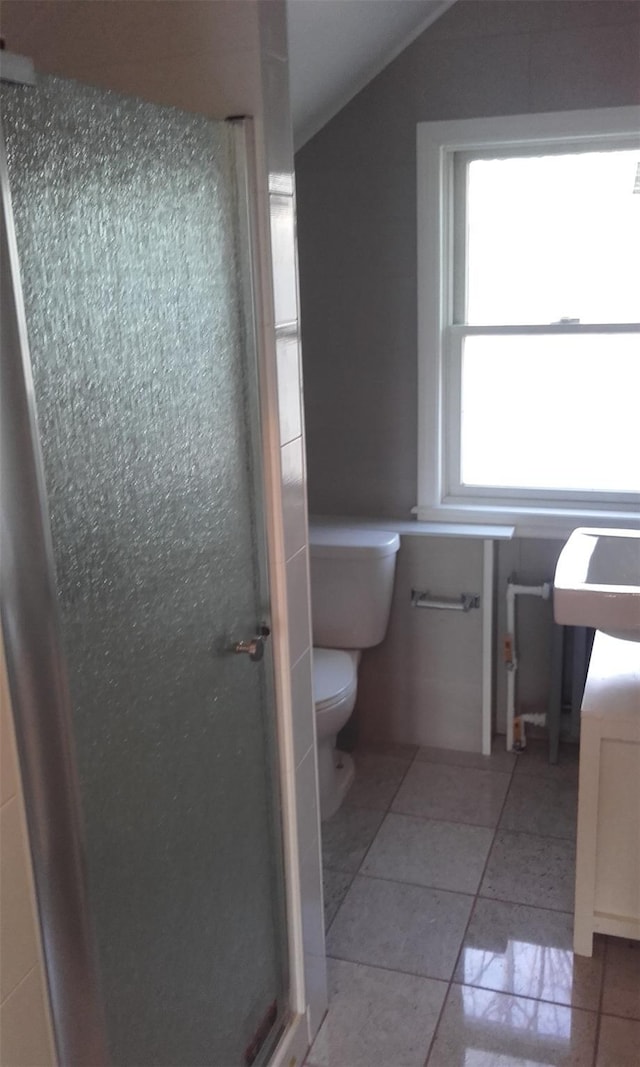 bathroom with toilet, walk in shower, and tile patterned flooring