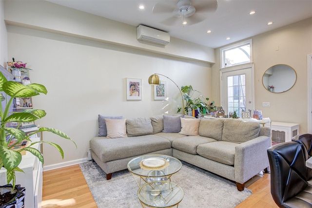 living room with hardwood / wood-style flooring, an AC wall unit, and ceiling fan