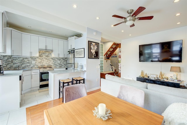 tiled dining room featuring ceiling fan and sink