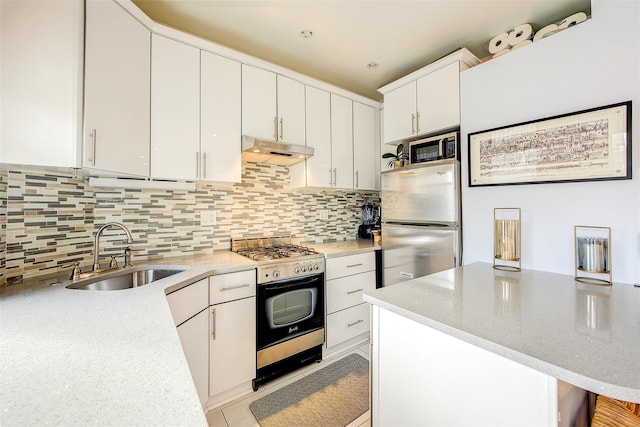 kitchen featuring stainless steel appliances, sink, decorative backsplash, and white cabinets