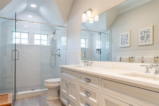 bathroom with vaulted ceiling, wood-type flooring, vanity, toilet, and a shower with door