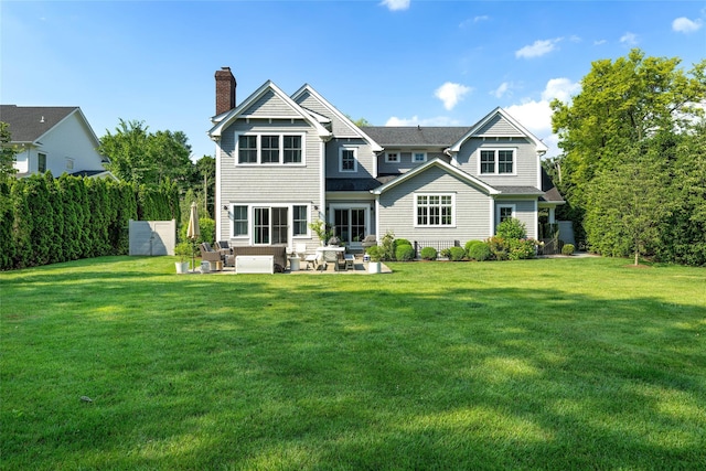 rear view of property featuring a yard and a patio