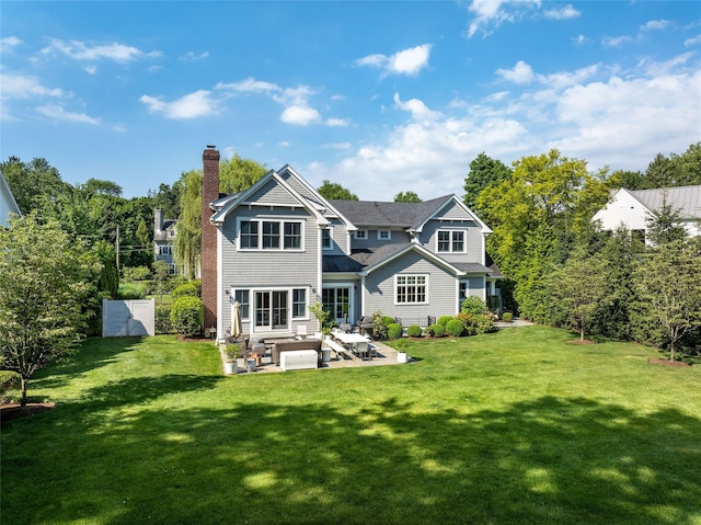 rear view of house with a patio and a lawn