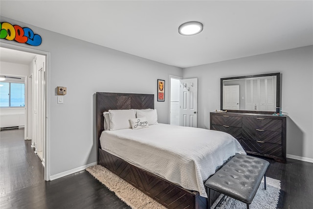 bedroom with a baseboard radiator and dark hardwood / wood-style floors