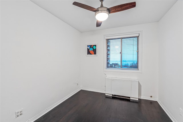 unfurnished room featuring ceiling fan, radiator, and dark hardwood / wood-style floors