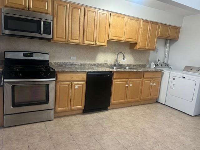 kitchen featuring stone counters, sink, decorative backsplash, independent washer and dryer, and stainless steel appliances