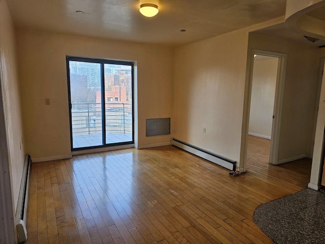 spare room featuring light hardwood / wood-style floors and a baseboard heating unit