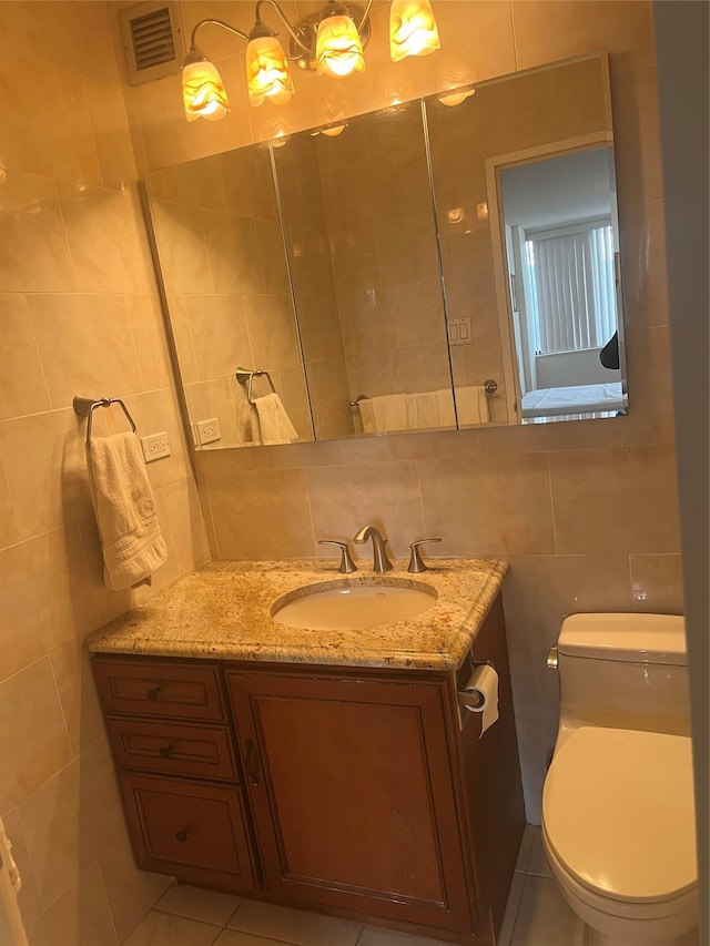 bathroom featuring decorative backsplash, vanity, tile walls, tile patterned flooring, and toilet