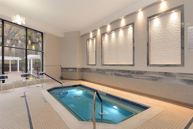 view of swimming pool featuring a chandelier and an indoor in ground hot tub