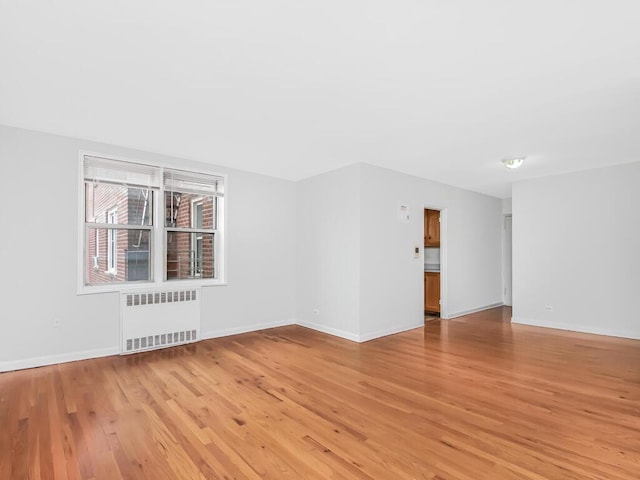 spare room with radiator and light wood-type flooring