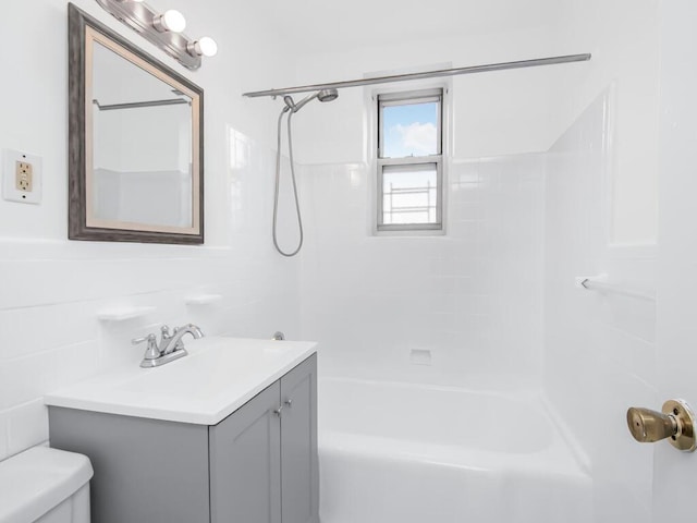 full bathroom with vanity, tiled shower / bath, and toilet