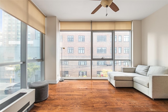 living area featuring wood-type flooring and ceiling fan