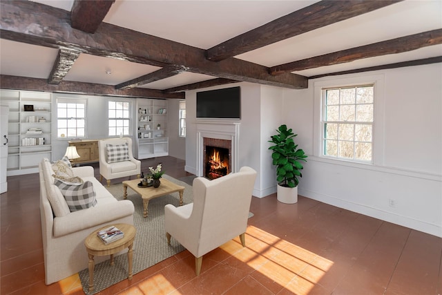 living room with beamed ceiling, built in shelves, and a brick fireplace