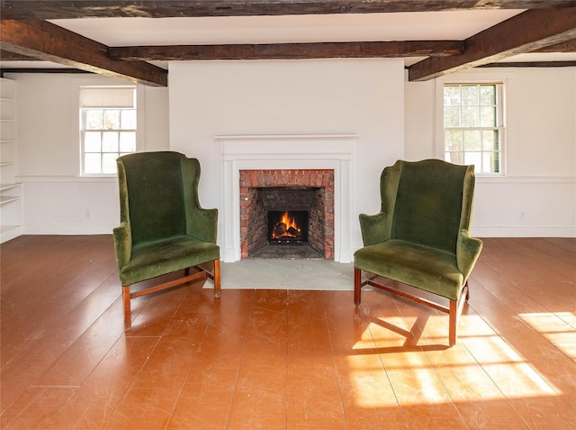 sitting room featuring beamed ceiling, wood-type flooring, and a fireplace