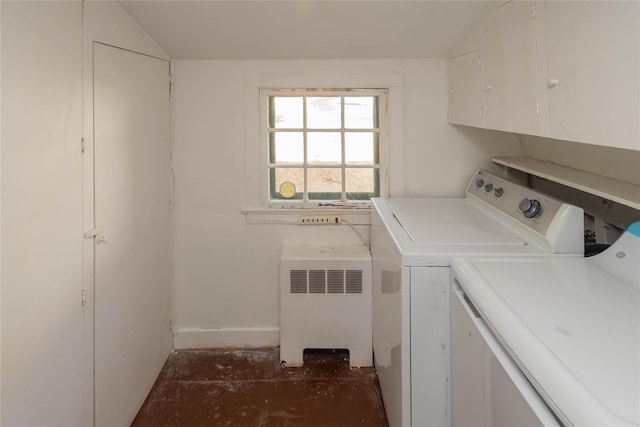 clothes washing area featuring washer and clothes dryer, cabinets, and radiator