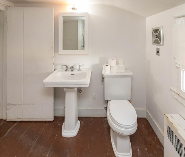 bathroom with hardwood / wood-style flooring, toilet, and radiator heating unit