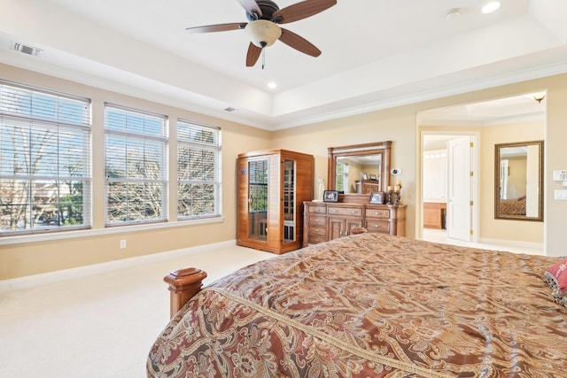 carpeted bedroom with a raised ceiling, ceiling fan, and ornamental molding