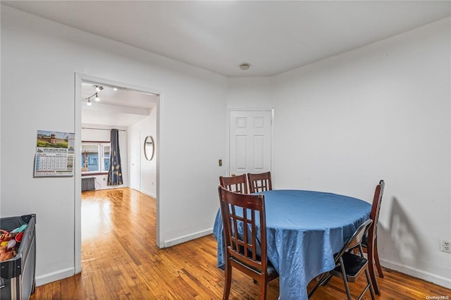 dining room with hardwood / wood-style flooring and radiator heating unit