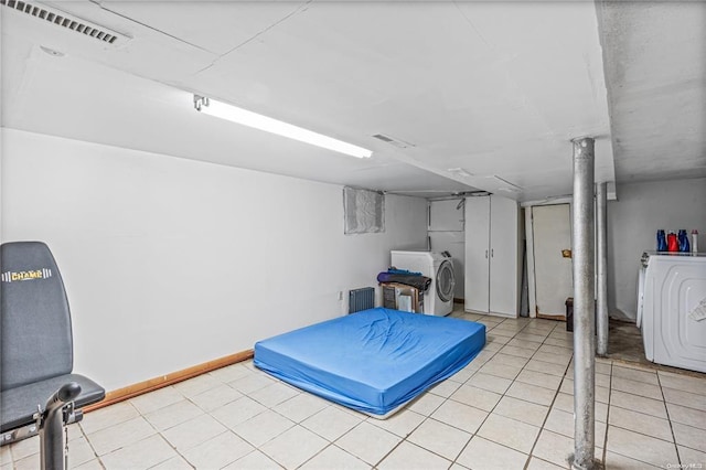 basement with light tile patterned flooring and washer / dryer