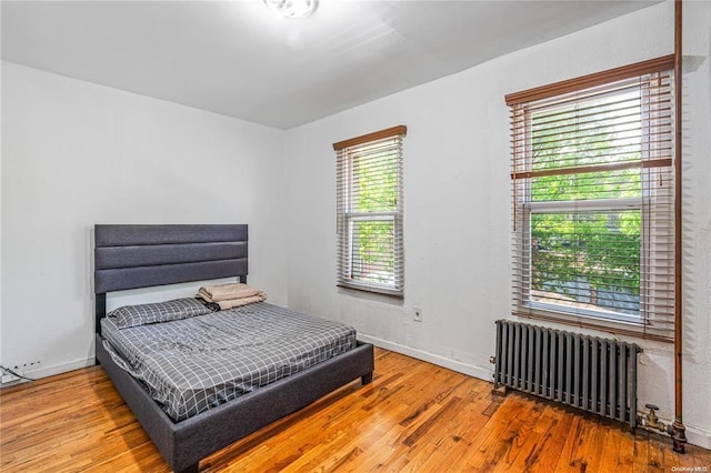 bedroom with radiator and hardwood / wood-style flooring