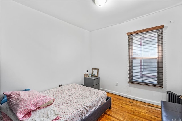 bedroom featuring wood-type flooring and radiator