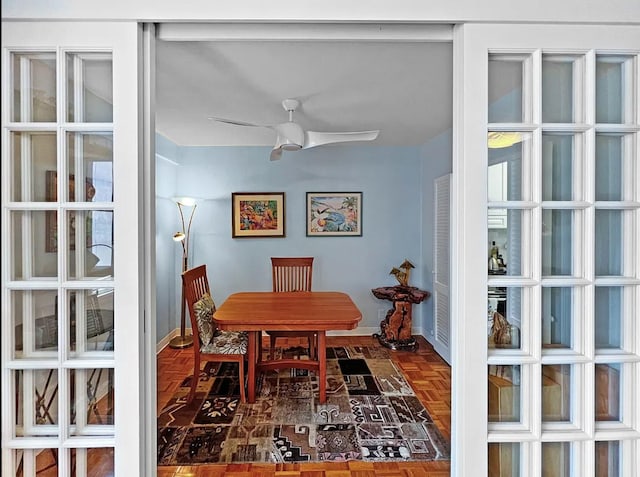 dining room featuring ceiling fan and dark parquet flooring