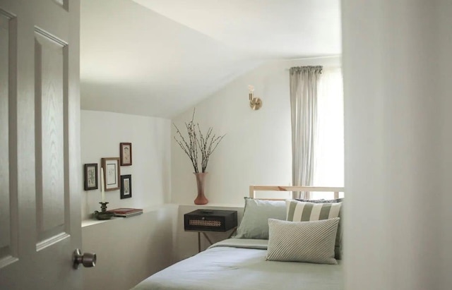 bedroom featuring multiple windows and lofted ceiling