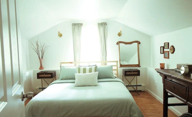 bedroom featuring light parquet flooring, vaulted ceiling, and a baseboard heating unit