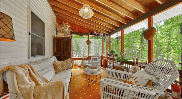 sunroom / solarium featuring vaulted ceiling with beams