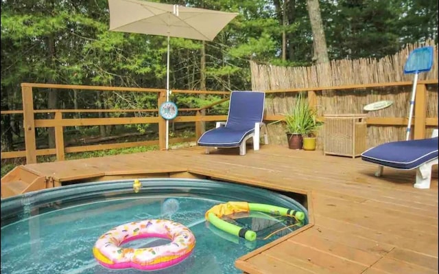 view of swimming pool featuring a deck and a jacuzzi