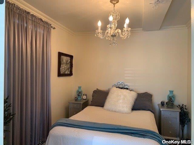 bedroom featuring crown molding and a chandelier