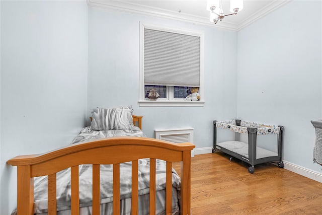 bedroom with light hardwood / wood-style floors and crown molding