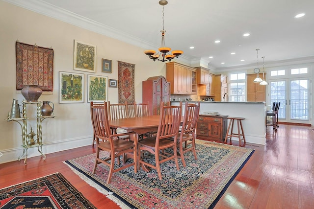 dining room featuring an inviting chandelier, french doors, crown molding, and dark wood-type flooring