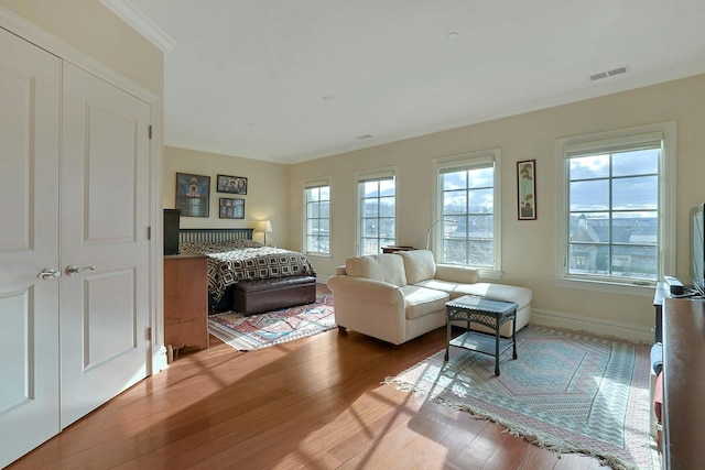 bedroom with multiple windows, a closet, and hardwood / wood-style floors