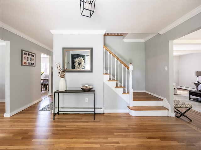 staircase with hardwood / wood-style flooring, baseboard heating, and crown molding