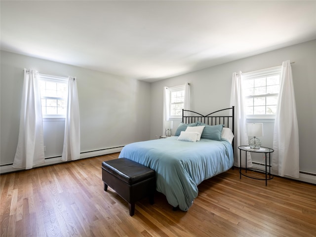 bedroom with wood-type flooring and multiple windows