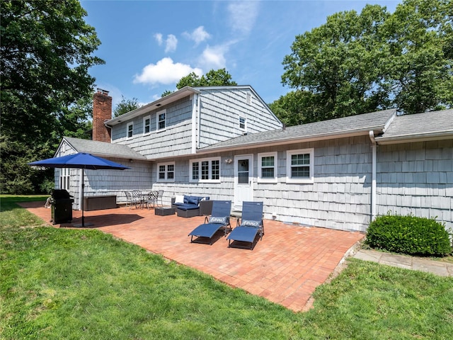 rear view of house with a lawn, a patio area, and an outdoor living space