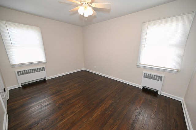 unfurnished room featuring radiator, ceiling fan, and dark hardwood / wood-style floors