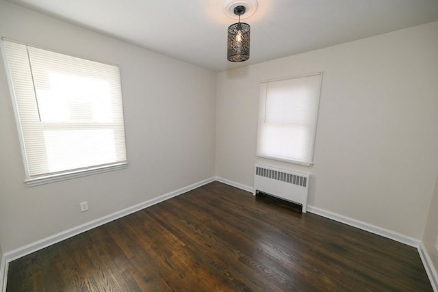 unfurnished room with radiator and dark hardwood / wood-style floors