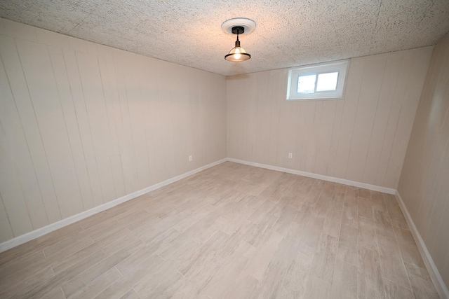 basement featuring light hardwood / wood-style floors and wooden walls