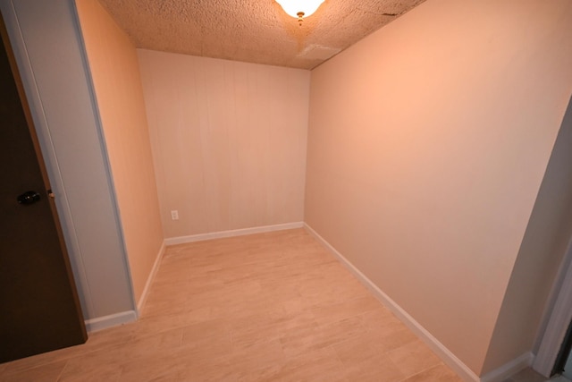 empty room featuring a textured ceiling and light wood-type flooring