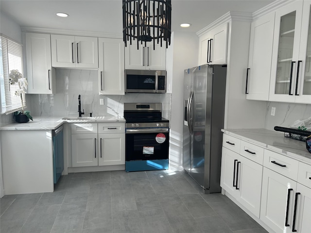 kitchen with light stone countertops, appliances with stainless steel finishes, sink, light tile patterned floors, and white cabinets