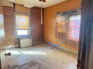 spare room featuring radiator and ceiling fan